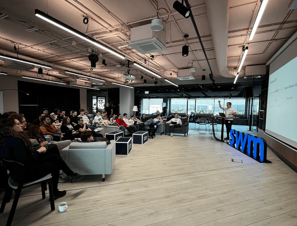 Photo of a speaker presenting to an audience at the Software Mansion Hackathon 2024